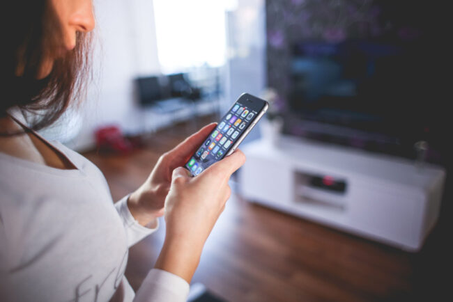 Woman looking at app icons on smartphone