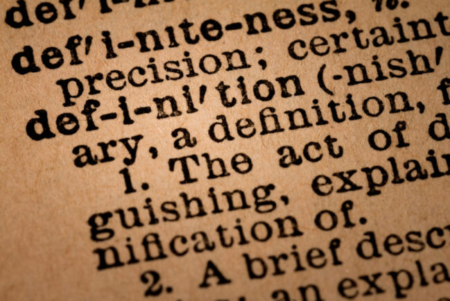 close up on dictionary page with a focus on the word "definition"