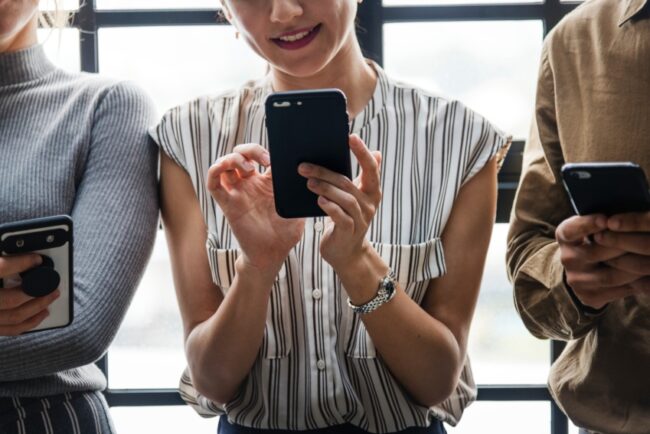 3 people using their smart phones