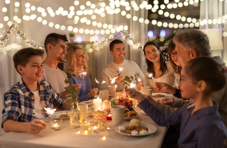 happy family with sparklers having fun at dinner party at home
