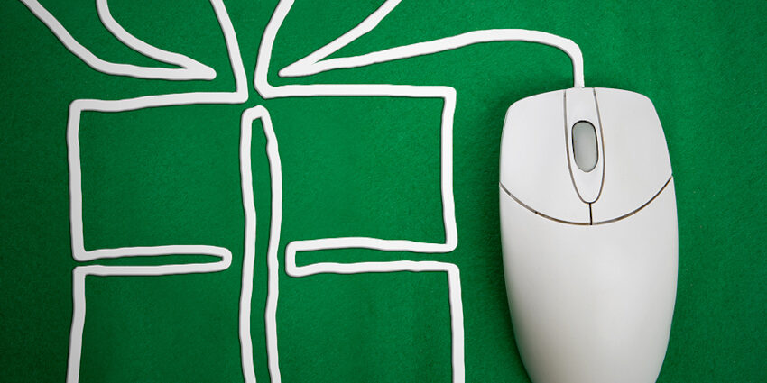 a wired mouse sits on a green surface; its wire is arranged to look like a present