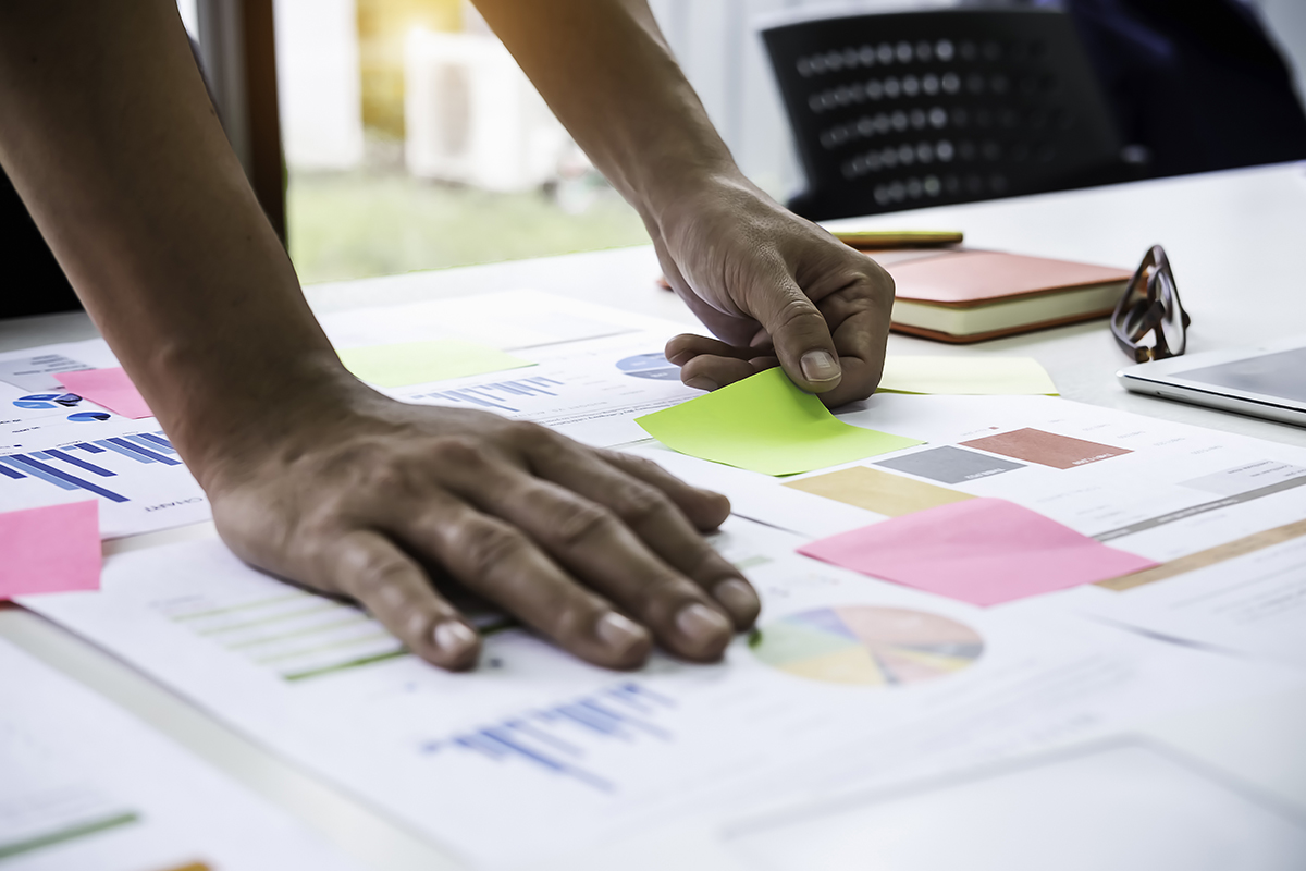 Man leans on a table full of charts & sticky notes