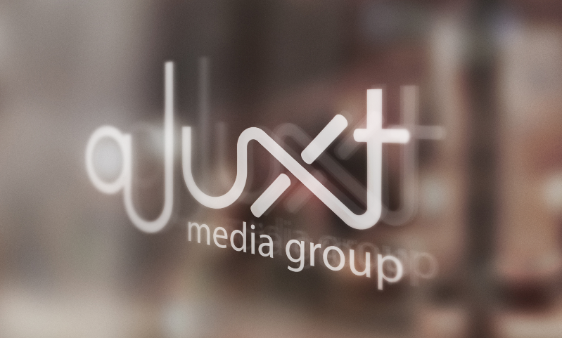 Text: "aJuxt Media Group" etched onto a glass door
