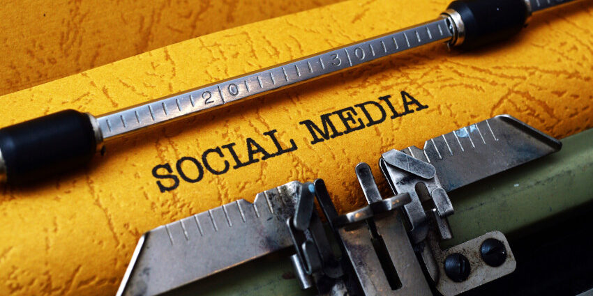 Close up on rustic paper in a typewriter with the typed text: "Social Media"