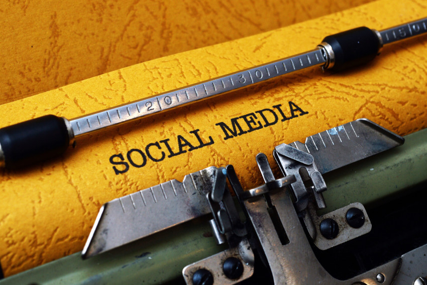 Close up on rustic paper in a typewriter with the typed text: "Social Media"