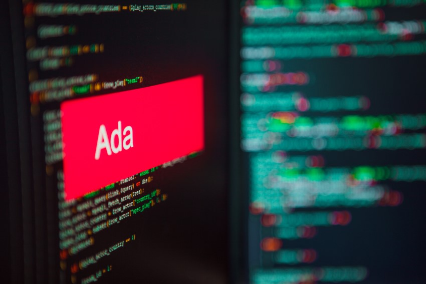 Red rectangle with white text: "Ada" in foreground; computer code in background