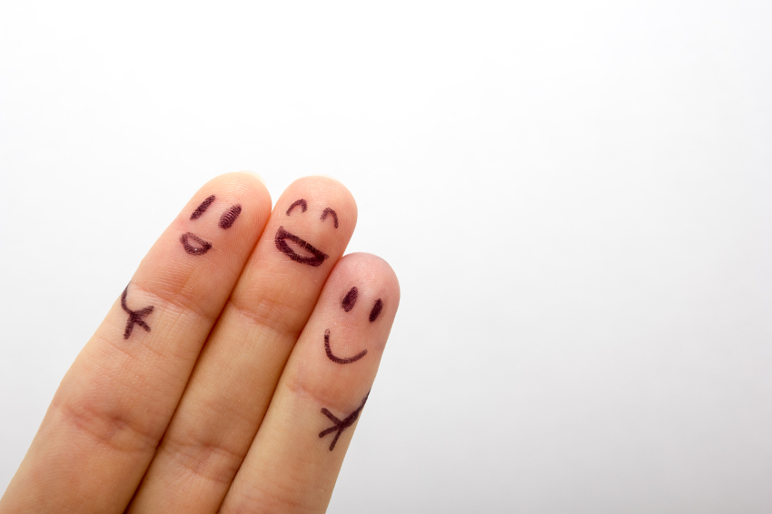 Close up on three fingers with faces drawn on them and clustered together