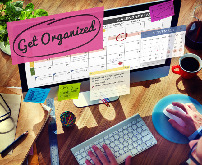 Person using a computer to organize their calendar with text "get organized"