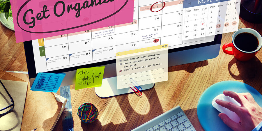 Person using a computer to organize their calendar with text "get organized"