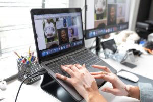 A woman types on a laptop that is sitting on a tilted stand