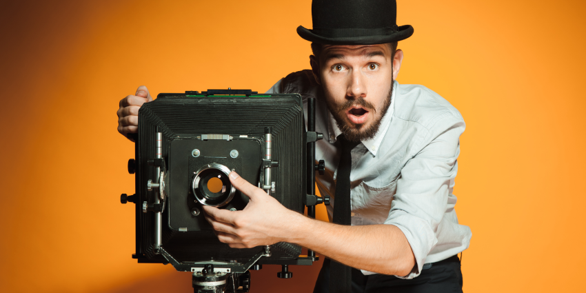 photography marketing tips featured image; man in bowler hat using an old-fashioned camera with surprised expression