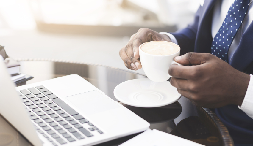 Business man Drinking Coffee Sitting At Laptop Working In Café