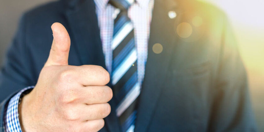 Man in business suit giving a thumbs up