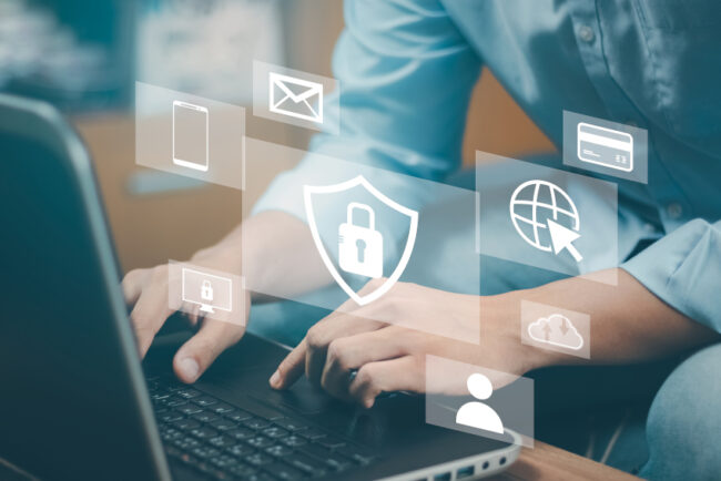 Person typing on a laptop keyboard; pop up icons representing email, mobile phones, security overlay