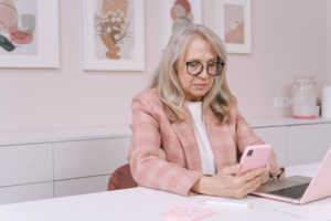 A middle-aged woman is looking at her phone and reading from it intently