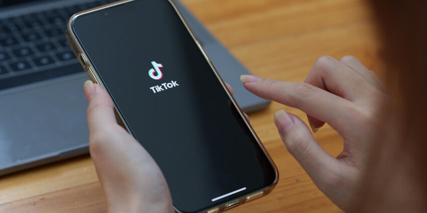 Tik tok logo (white on black background) on a smart phone screen