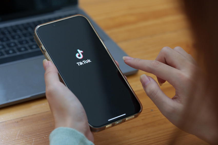 Tik tok logo (white on black background) on a smart phone screen