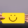 A hand is grabbing a yellow-colored text bubble with a smiley face as a second person's hand lets go