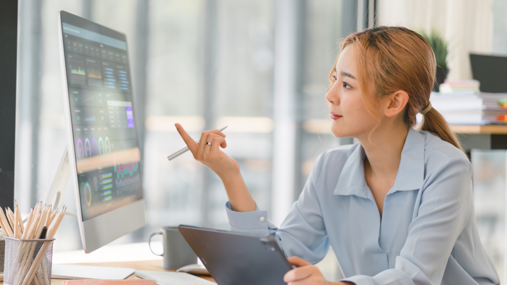 Woman talking while gesturing towards a computer screen