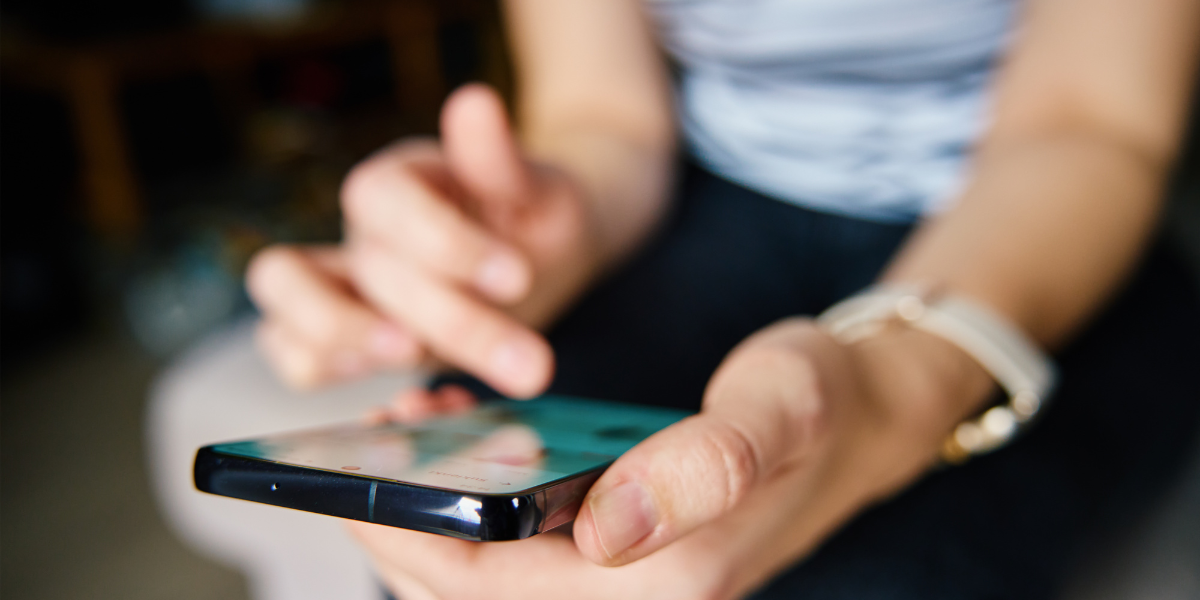 Person using a smartphone with one hand while tapping the screen.